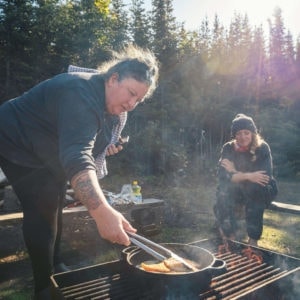 sitting and cooking over the fire