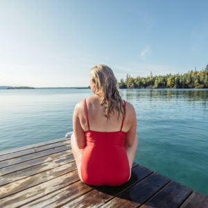 blonde, red bathing suit at the end of the dock