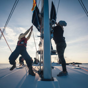 women at mast raising the sail